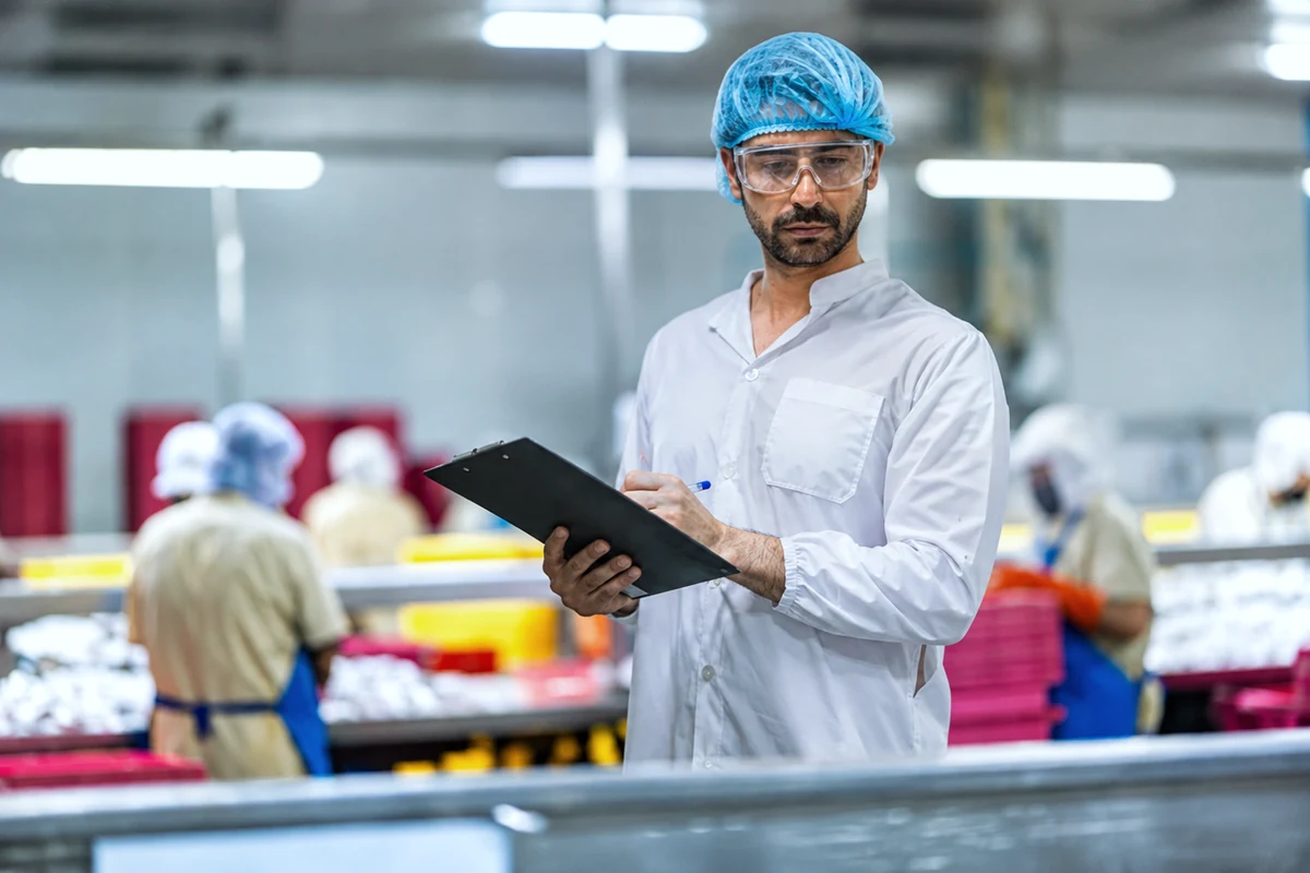Food safety supervisor reviewing work in a modern processing environment